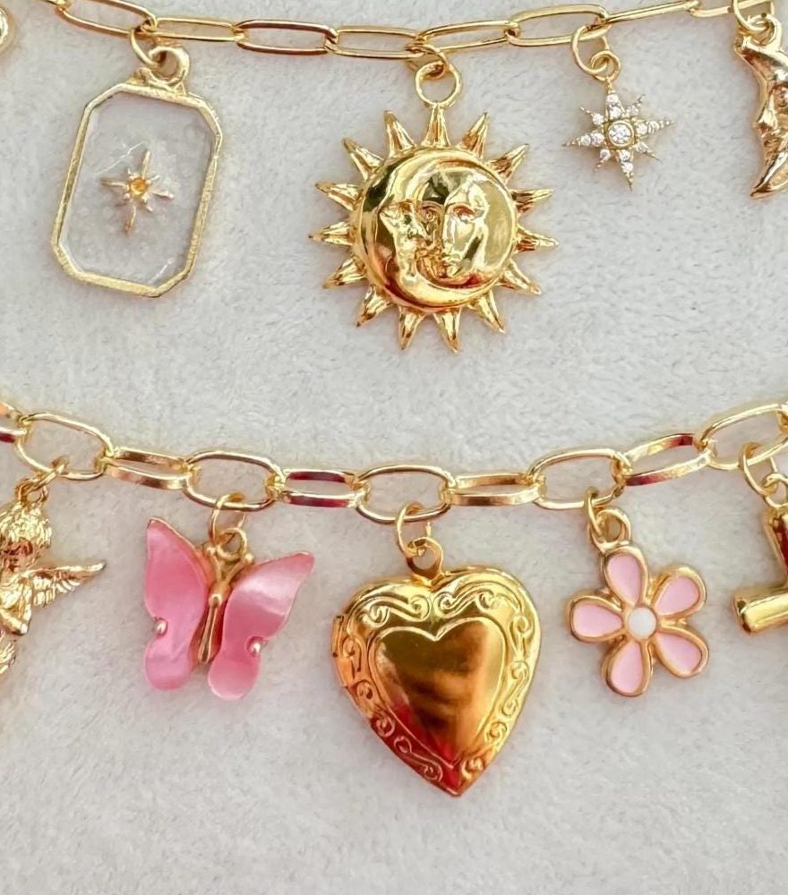 Sun, butterfly, heart locket and flower charms on a gold chain